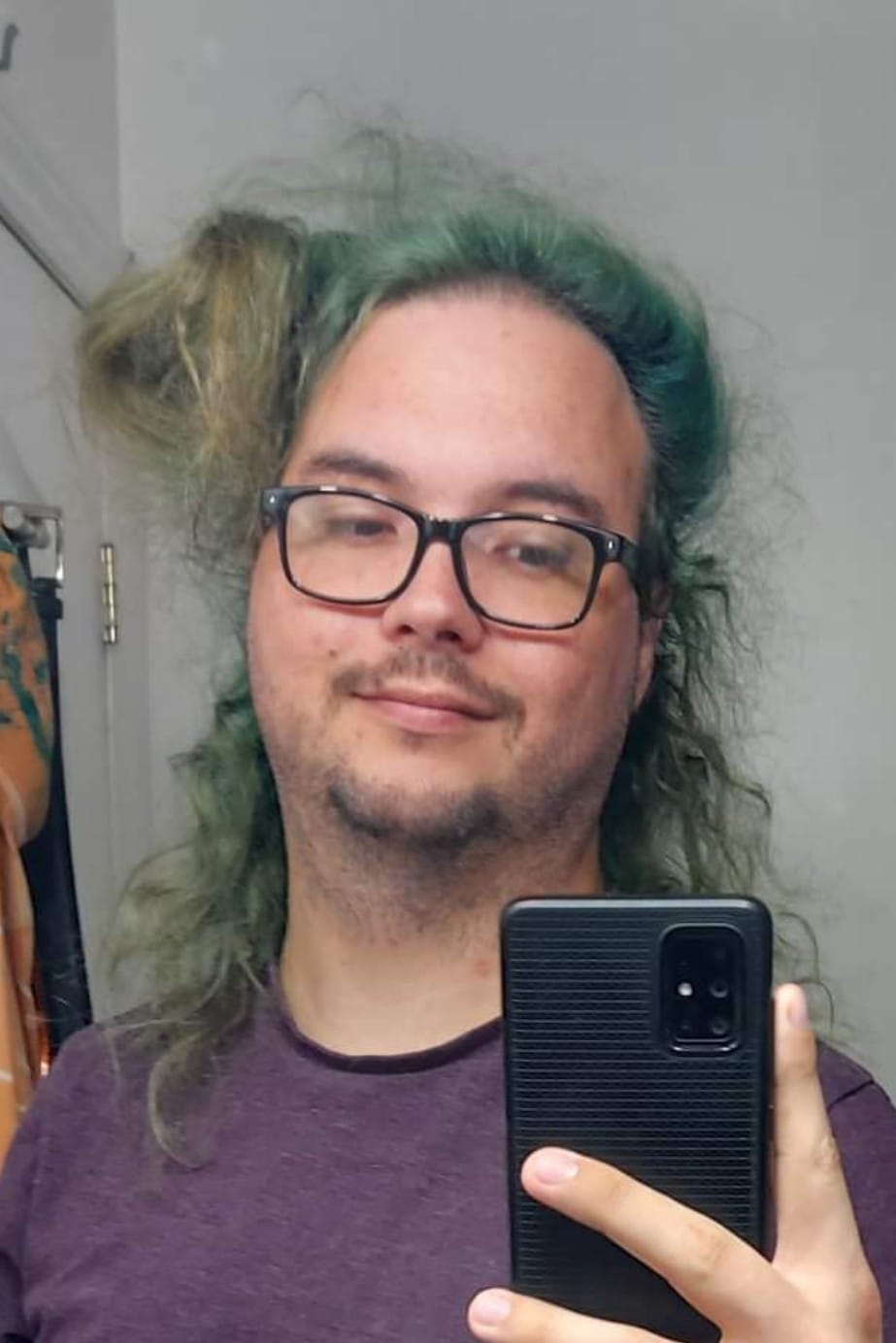 A man with long green hair and no beard is taking a mirror selfie, Photo 2